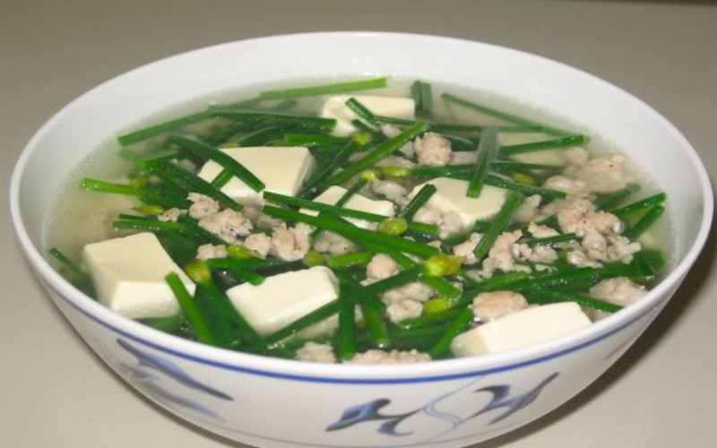 Canh hẹ là một món canh truyền thống của Việt Nam, nổi bật với hương vị thanh mát và hương thơm đặc trưng của lá hẹ. Món canh này thường được nấu với đậu hũ non và một ít thịt heo xay để tạo nên hương thơm và dinh dưỡng cho món ăn. Vị ngọt tự nhiên của lá hẹ kết hợp cùng với các gia vị đi kèm tạo nên hương vị thanh mát đặc trưng rất phù hợp cho những ngày hè nắng nóng. Món ăn này không chỉ nhìn ngon miệng bởi màu sắc bắt mắt mà còn vô cùng thanh đạm và bổ dưỡng, trở thành một lựa chọn thú vị trong thực đơn hằng ngày của gia đình Việt.