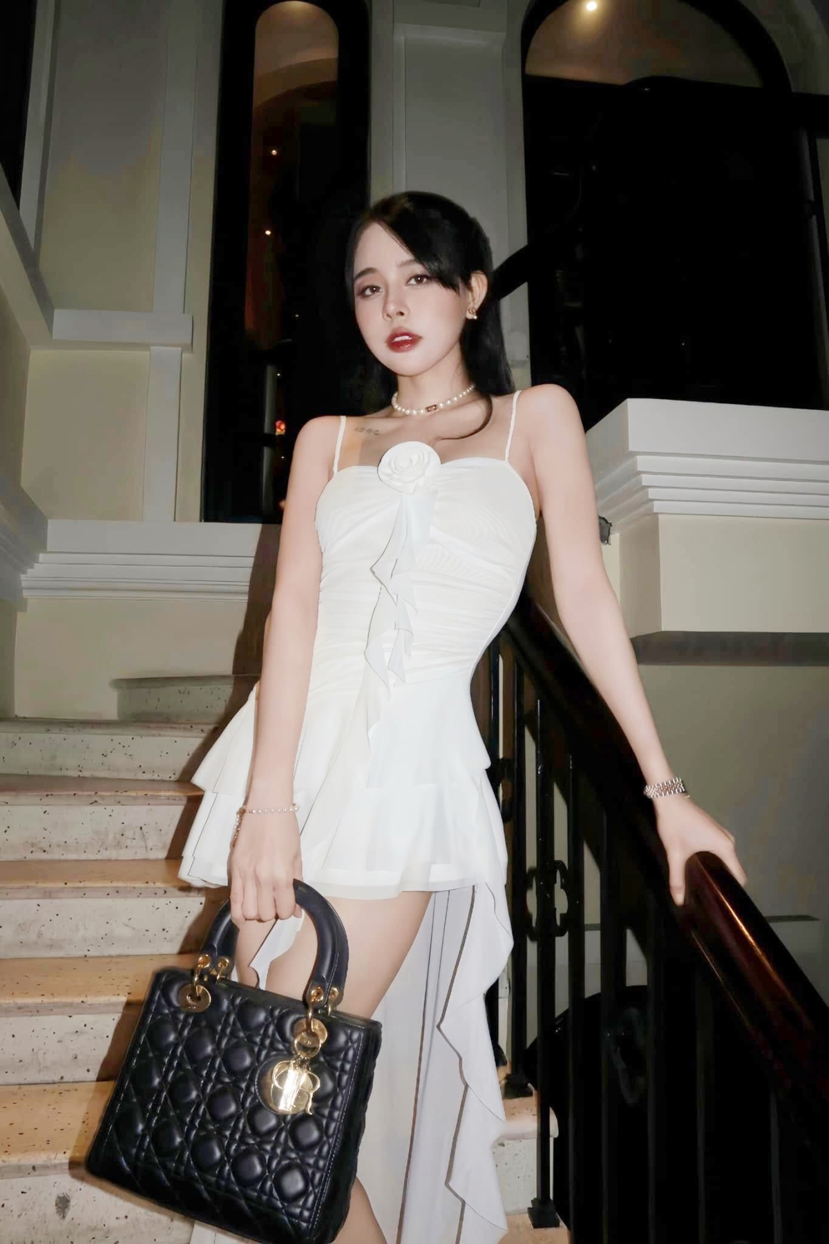 Cô thể hiện phong cách Y2K qua váy xếp bèo, nhấn bằng túi Dior.