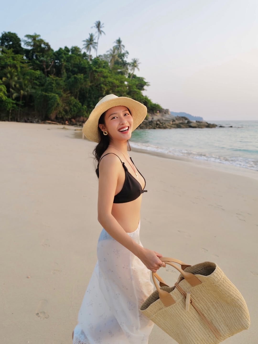Diễn viên Khả Ngân cũng lựa chọn kiểu dáng này, phối chân váy mỏng, mũ rộng vành và túi cói khi đi chơi ở Phuket, Thái Lan.