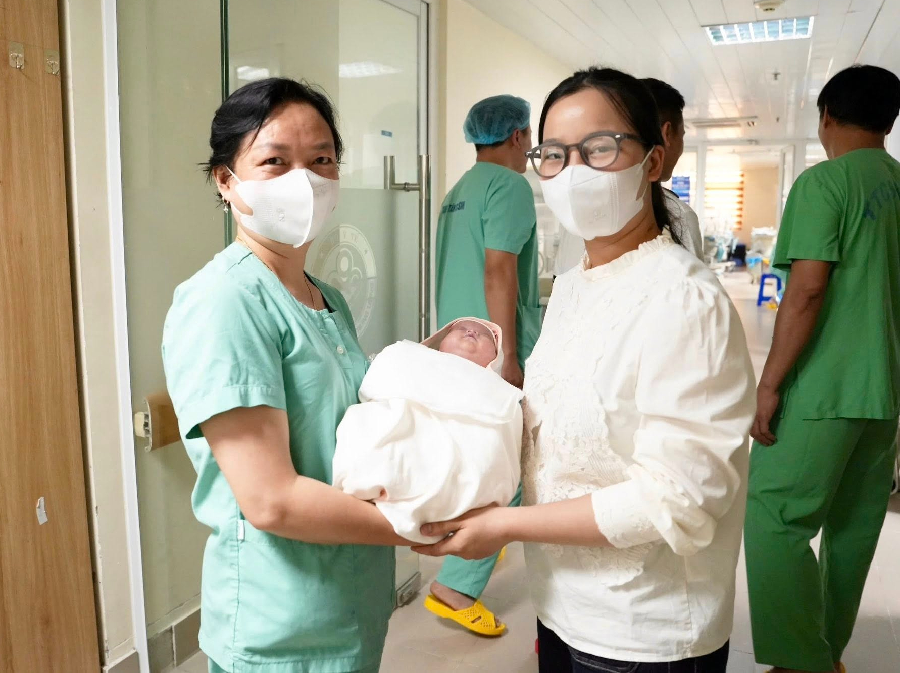 Mẹ của Dương đón con từ điều dưỡng trưởng của Trung tâm Sơ sinh.