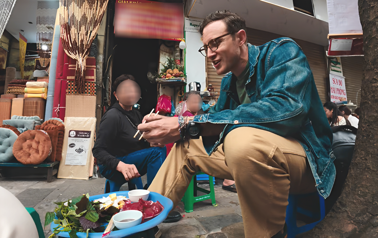 Khách Tây thưởng thức món sứa đỏ ở một quán bản địa lâu đời trên phố Hàng Chiếu, Hà Nội. Ảnh: Andrew Fraser