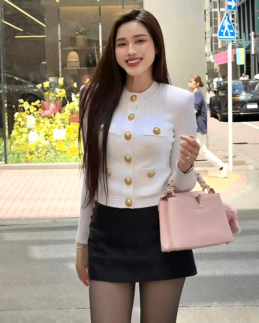 Mỹ nhân Thanh Hóa kết hợp áo cardigan để giữ ấm trong thời tiết se lạnh, phối cùng chân váy đen ngắn tôn đôi chân 1,11 m.