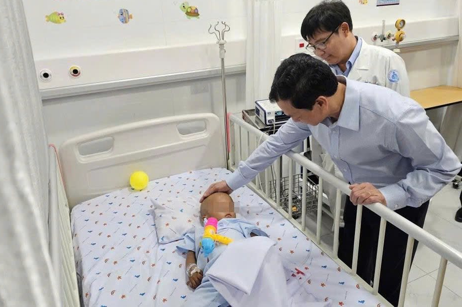 PGS.TS Nguyễn Tri Thức, Thứ trưởng Bộ Y tế thăm bé N.G.K. Ảnh: BVCC.