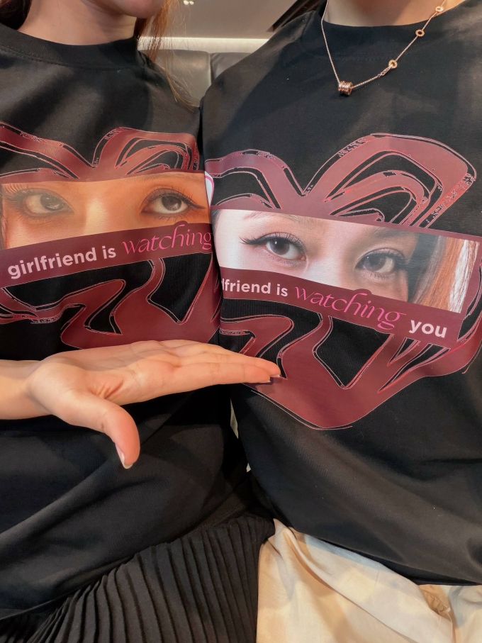 Chiếc áo được cả hai in riêng có đôi mắt của đối phương cùng dòng chữ My girlfriend is watching you.