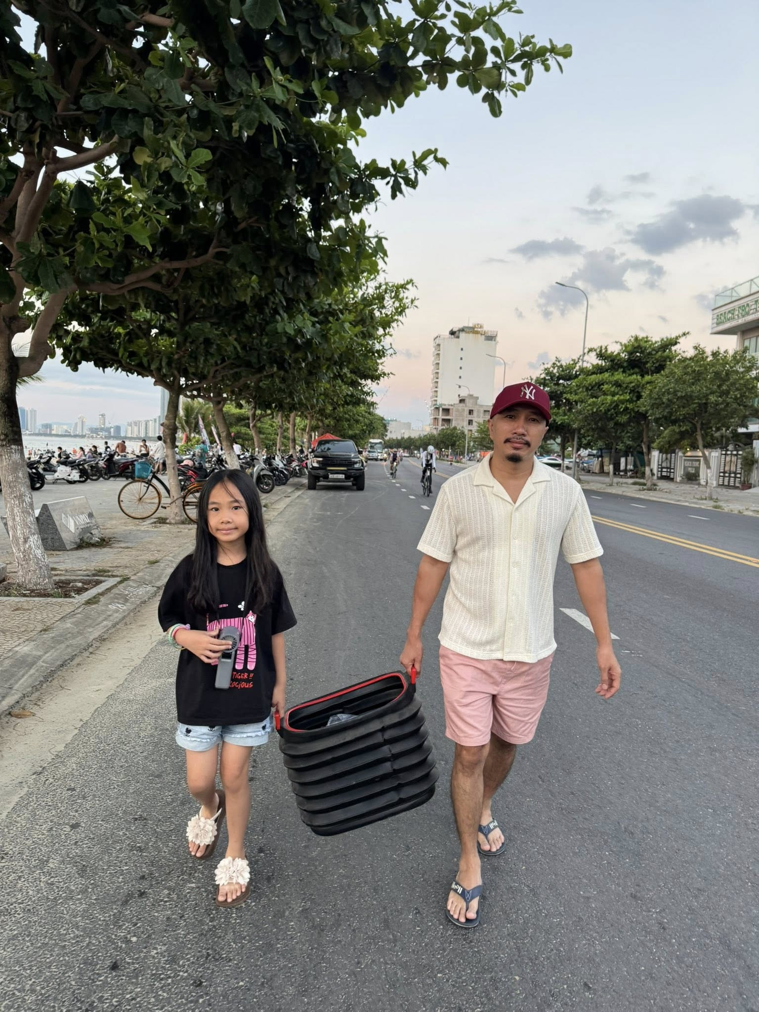 Chồng và con gái chị Oanh khệ nệ mang thành quả là những loại hải sản tươi rói vừa mua từ chợ về nơi lưu trú