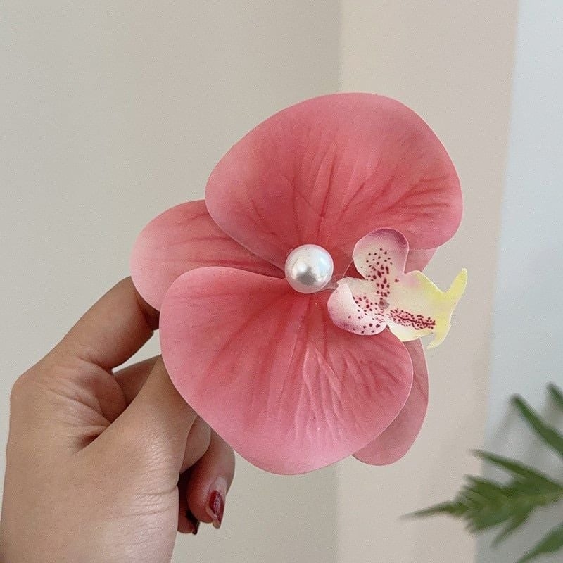 Để hoàn thiện tổng thể, Hòa Minzy chọn cài tóc hoa lan bằng vải giá khoảng 50.000 đồng, tạo điểm nhấn nhẹ nhàng. Tổng giá trị trang phục và phụ kiện của ca sĩ gần 283 triệu đồng.