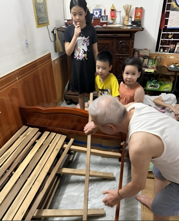 Cụ ông sửa lại giường sau khi bị các cháu nhảy sập chỉ sau 5 phút tới thăm. Ảnh gia đình cung cấp