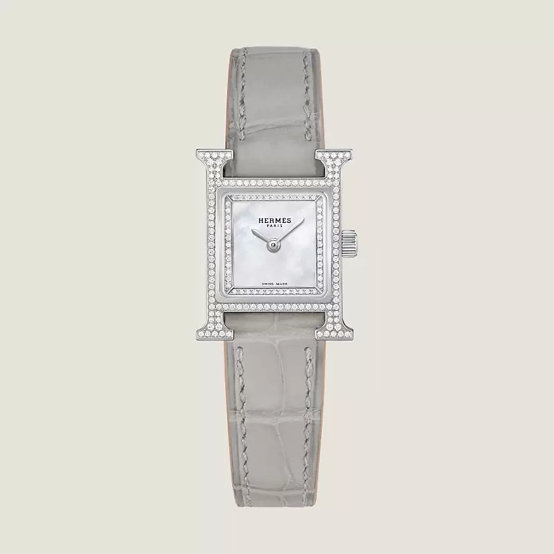 Chiếc đồng hồ có phần vỏ tạo hình chữ H đặc trưng, nạm tổng cộng 168 viên kim cương trên vỏ và mặt số, kết hợp dây da cá sấu màu xám ngọc trai. Theo niêm yết của hãng, thiết kế được bán với giá 11.175 USD (khoảng 292 triệu đồng). Ảnh: Hermes