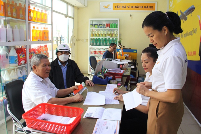 Chi trả lương hưu cho người hưởng tại một điểm bưu điện. Ảnh: TTXVN
