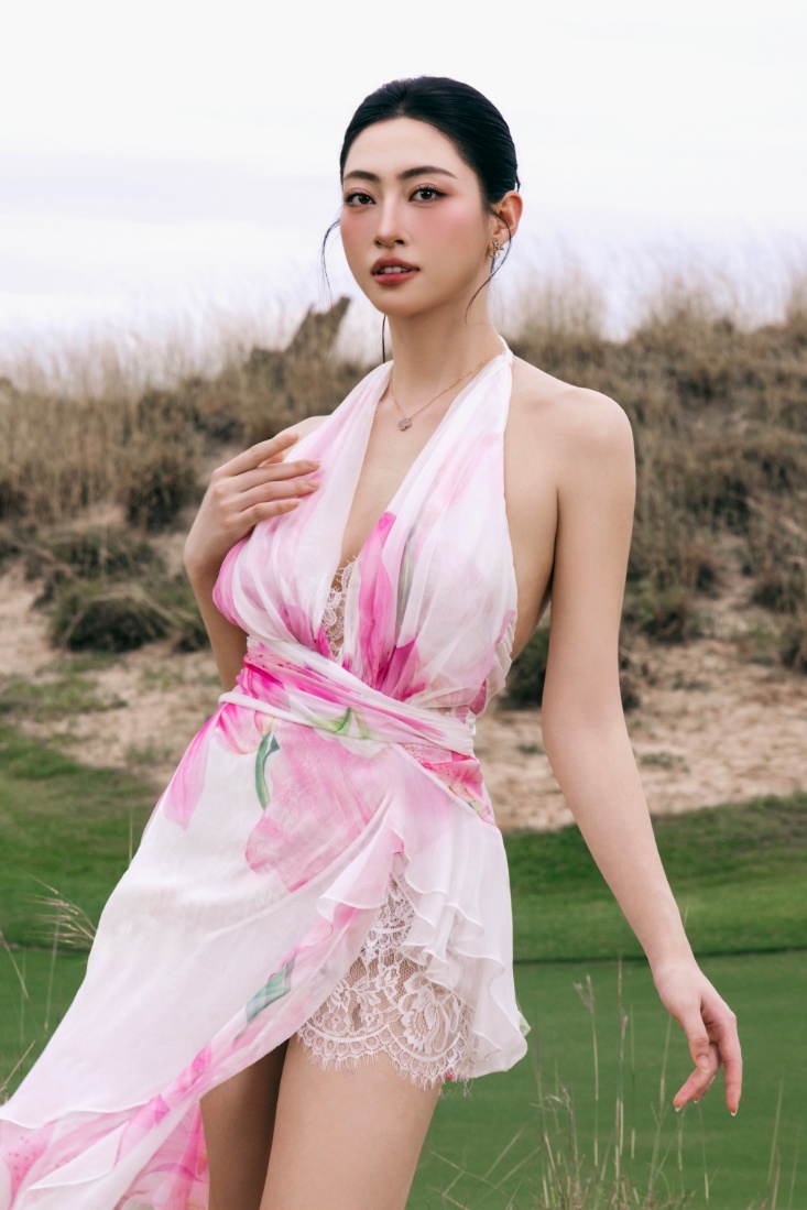 Hoa hậu Thế giới Việt Nam 2019 Lương Thùy Linh chọn đầm maxi họa tiết hoa ly với phần cổ yếm tạo cảm giác vừa mềm mại, vừa sắc sảo.