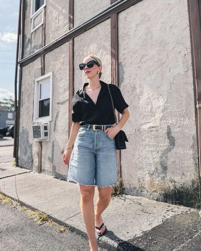 Sơ mi đen dáng ngắn phối cùng quần bermuda denim tạo nên tổng thể tối giản nhưng sắc sảo. Điểm nhấn thắt lưng và kính mát giúp outfit thêm phần cá tính, hiện đại.