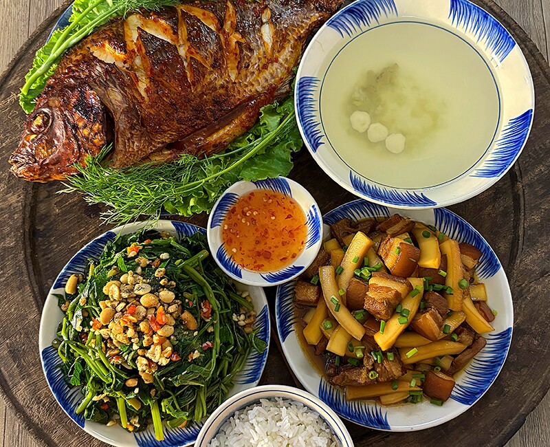 Mâm cơm này gồm các món: Cá nướng, nộm rau muống, thịt kho dừa