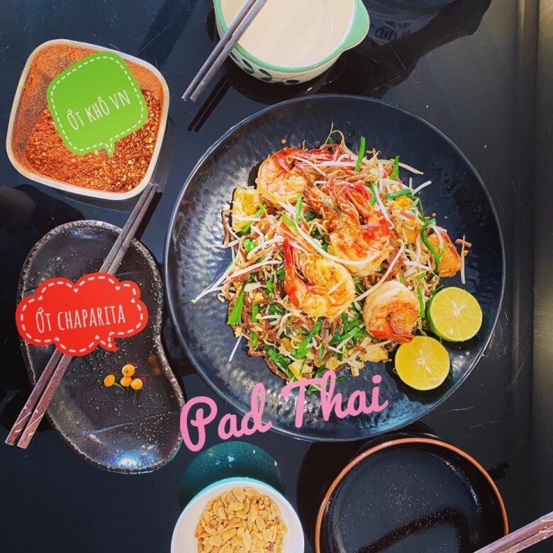 Đĩa Pad Thai (Phở xào kiểu Thái) lên màu cực chuẩn với những con tôm to tròn, râu mực và đậu hũ chiên. Món ăn được dọn kèm đậu phộng giã dập, chanh tươi và hai loại ớt bột đặc biệt mang lại trải nghiệm ẩm thực đường phố Bangkok ngay tại nhà.
