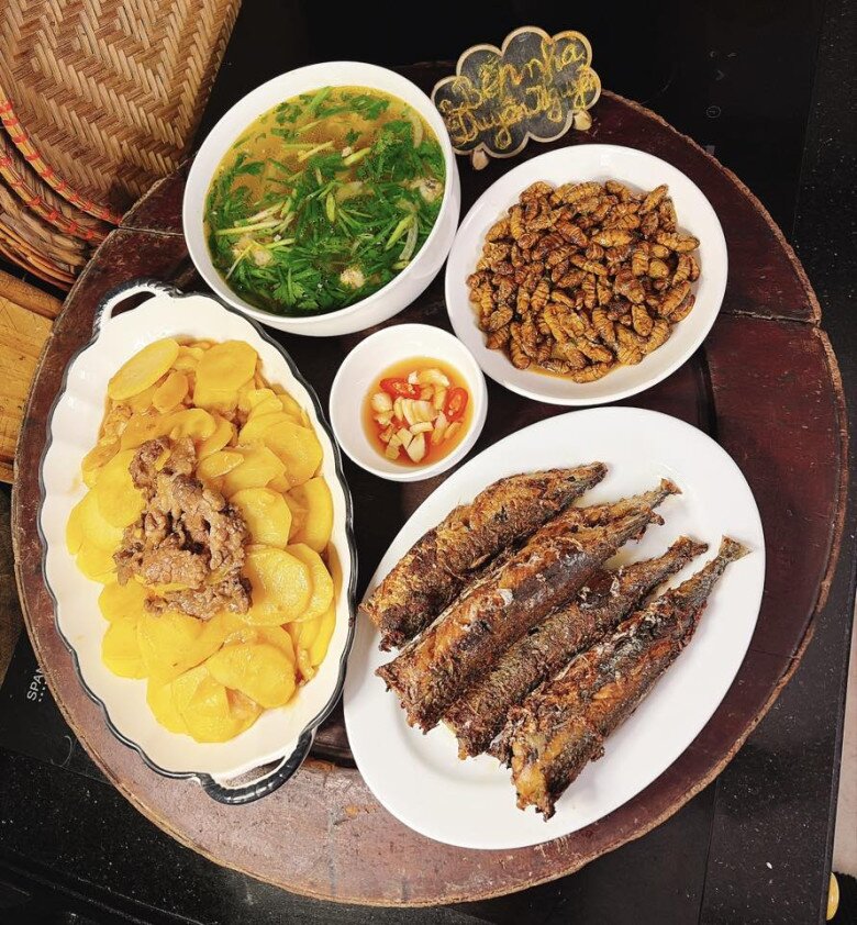 Mâm cơm này gồm các món: - Cá nục chiên riềng sả - Khoai tây xào thịt bò - Nhộng rang - Canh măng mọc