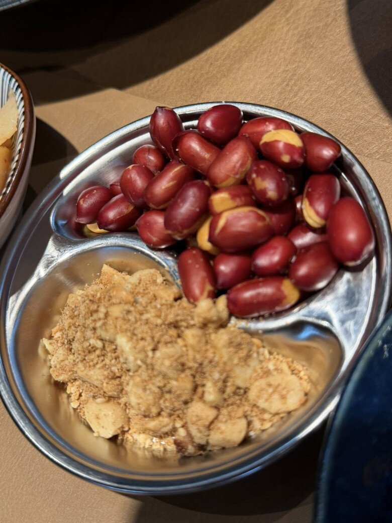 Một khay nhỏ chia đôi đựng lạc rang nguyên hạt bóng bẩy và muối lạc vừng giã nhỏ thơm bùi. Đây là những món gia vị, món ăn kèm đậm chất truyền thống không thể thiếu trong các mâm cơm gia đình miền Bắc.