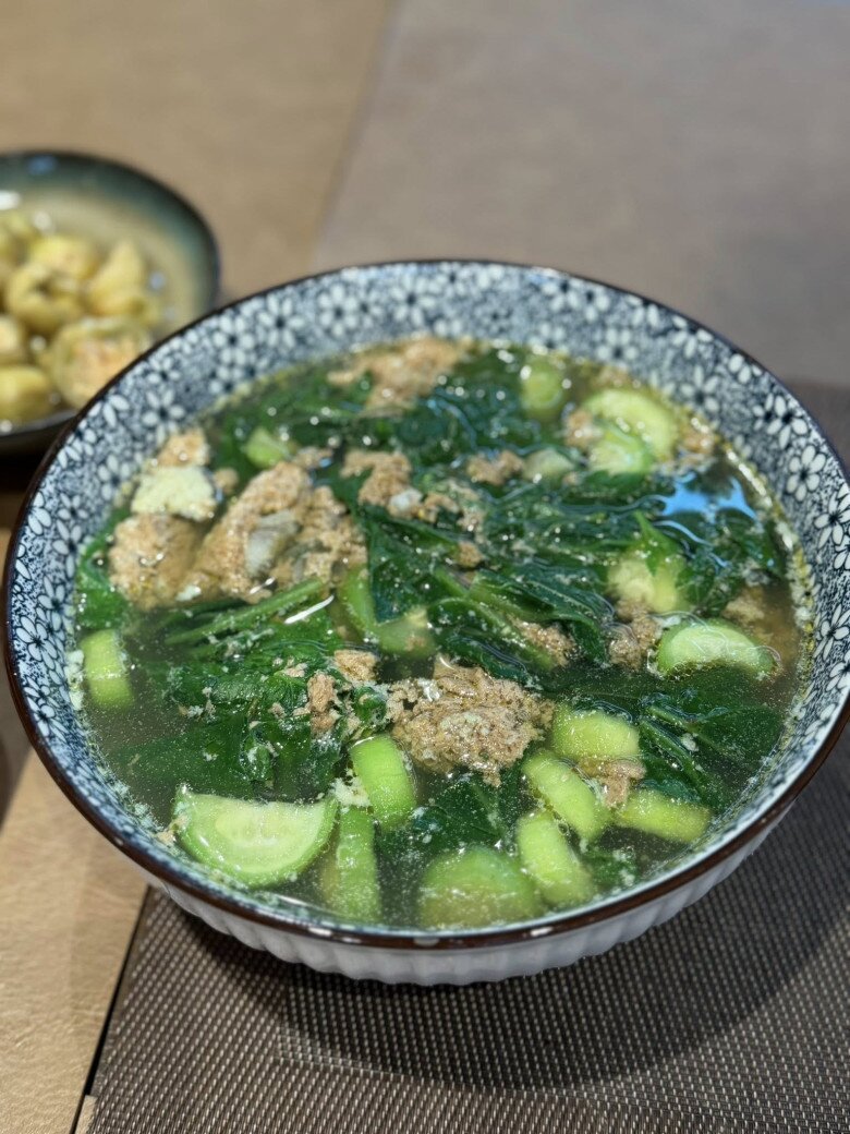 Bát canh cua đồng nấu cùng rau mồng tơi và mướp hương thơm ngát, nổi bật với phần gạch cua đóng thành từng tảng lớn béo ngậy. Kỹ thuật nấu canh cua nhiều gạch thế này chứng minh tay nghề bếp núc không phải dạng vừa của cựu người mẫu.
