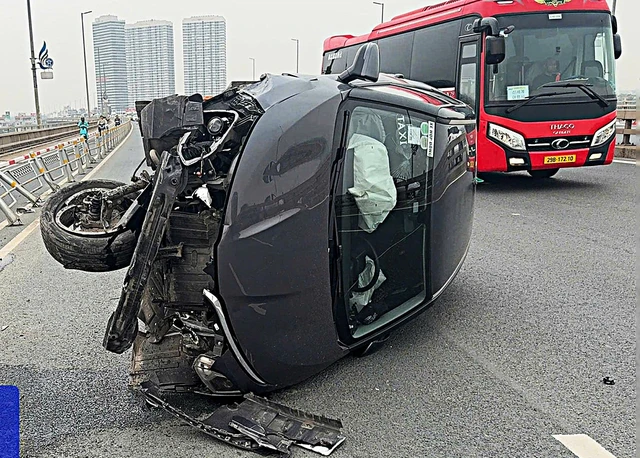 Do không làm chủ tay lái vì buồn ngủ, tài xế taxi đã tông vào rào chắn trên cầu Nhật Tân khiến xe lật nghiêng, đầu biến dạng.