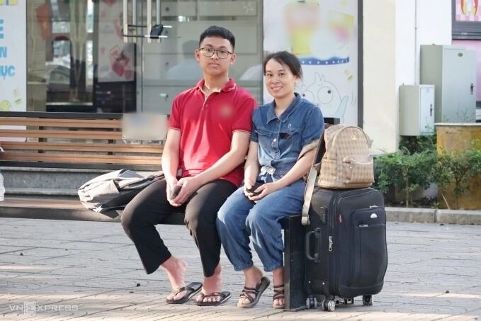 Chị Kiều và con trai mang theo vali, quần áo để dự kỳ thi lớp 10 trường chuyên Sư phạm, sáng 4/6. Ảnh: Thanh Hằng