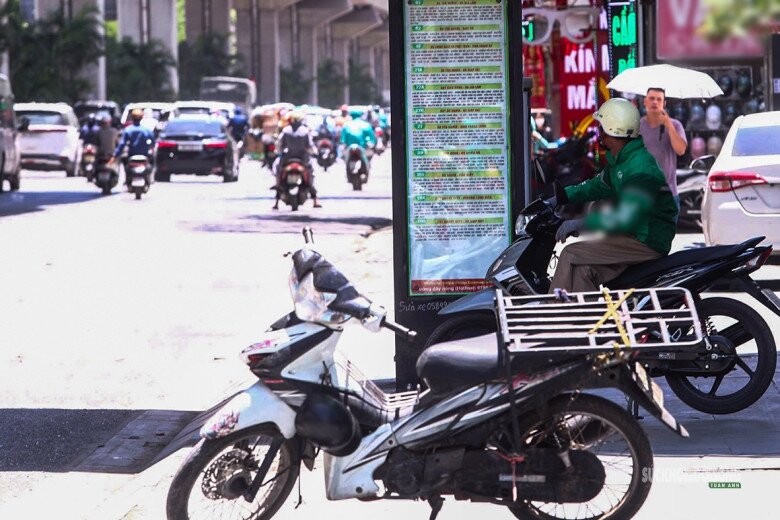 Tài xế xe công nghệ và người đi đường tranh thủ dừng dưới bóng râm, gầm cầu hoặc mái hiên để tránh nắng.