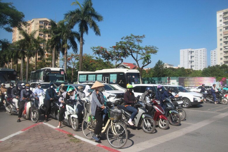 Người đi làm buổi sáng cũng uể oải khi chờ đèn đỏ giữa đường bê tông với nền nhiệt cao 