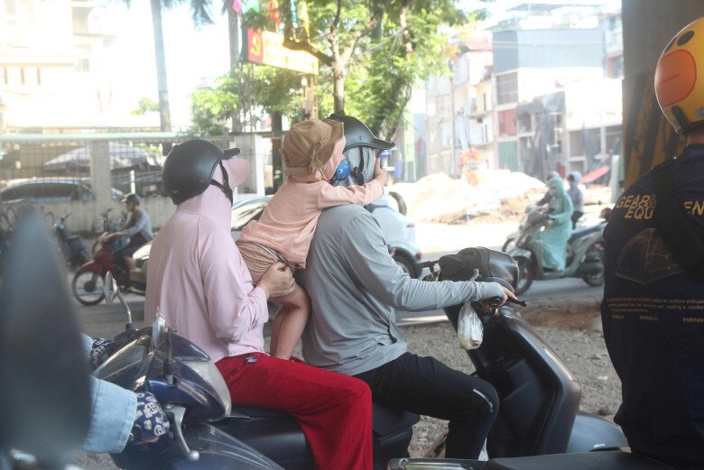 Nhiều người chọn tránh nắng tạm trong bóng râm khi chờ đèn đỏ 