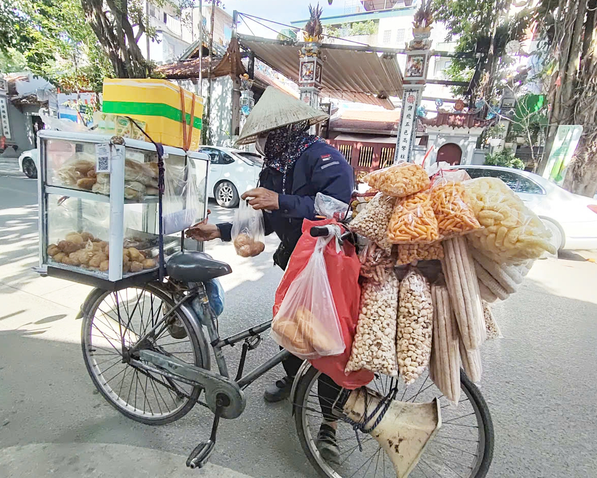 Một chiếc bánh rán được 3.000 đồng, chẳng lời lãi bao nhiêu nhưng cô Tân vẫn chăm chỉ đạp xe bán hàng giữa thời tiết nắng gắt