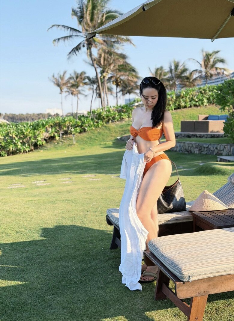 Bộ bikini màu cam tôn lên nước da trắng sáng của cô.
