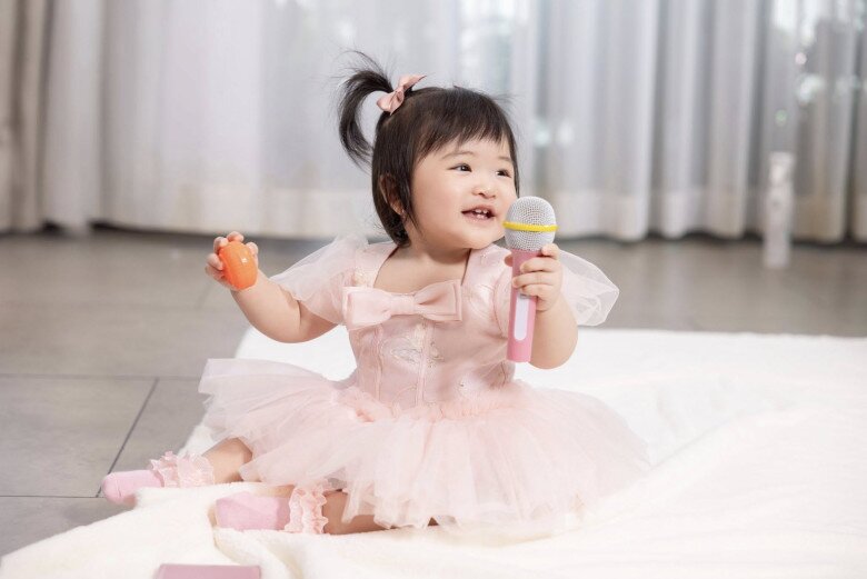 Bé Anya bóc chiếc micro màu hồng đáng yêu trong ngày thôi nôi.