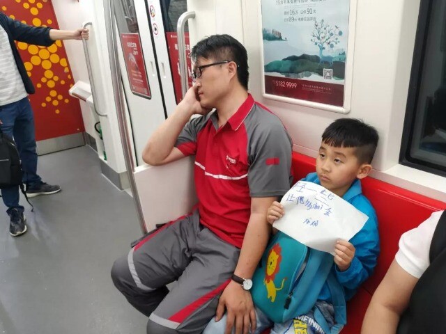 Bố làm shipper ngủ gật, bé trai giơ tờ giấy Xin mọi người nói nhỏ trên tàu điện, dân mạng: Đây mới là ông bố giàu có