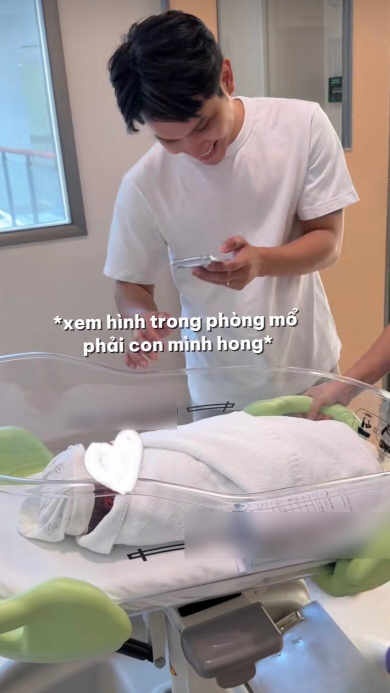 Chồng Á hậu Chế Nguyễn Quỳnh Châu cẩn thận xem hình trên điện thoại trước khi nhận con từ điều dưỡng bệnh viện - 2