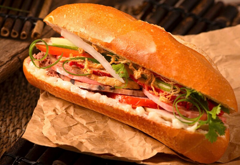 Bánh mì Việt Nam chinh phục thực khách quốc tế bởi lớp vỏ giòn rụm, ruột mềm nhẹ và phần nhân đầy đặn. Một ổ bánh mì nóng hổi tay, thêm thịt, chả, đồ chua, rau thơm và xốt béo mặn đủ để đánh thức vị giác của bất kỳ ai. 