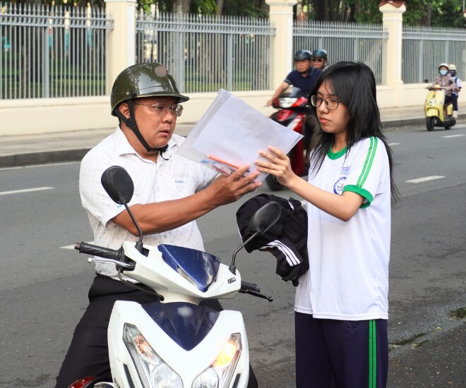 Các sĩ tử được bố mẹ đưa đến điểm thi, tranh thủ kiểm tra lại vật dụng trước khi bước vào phòng thi.