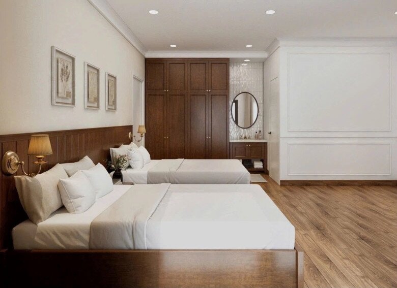 Hình ảnh mô phỏng phòng ngủ dành cho khách hoặc người thân ghé chơi được trang bị hai giường đôi rộng rãi. Nội thất gỗ tông màu trầm ấm kết hợp hài hòa với các đường phào chỉ thanh lịch trên tường.