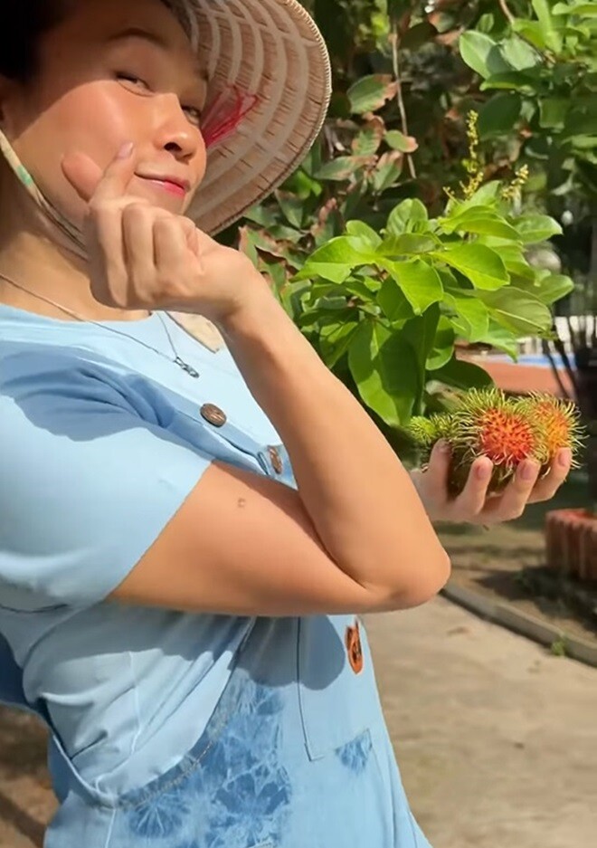 Nữ nghệ sĩ gửi nụ cười rạng rỡ cùng hành động thả tim cực kỳ đáng yêu tới những người luôn theo dõi và ủng hộ hành trình của mình. Trên tay cô là thành quả ngọt ngào sau chuỗi ngày vun xới, tưới tắm cho mảnh vườn ngập tràn bóng mát.