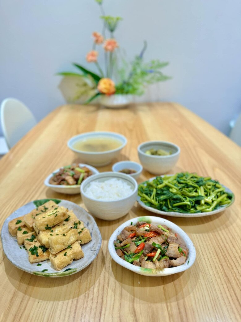 Bàn ăn bằng gỗ tự nhiên với thiết kế tối giản, trên bàn không thể thiếu lọ hoa trang trí tạo nên không gian ăn uống gần gũi và nhẹ nhàng cho gia đình cặp đôi nổi tiếng.