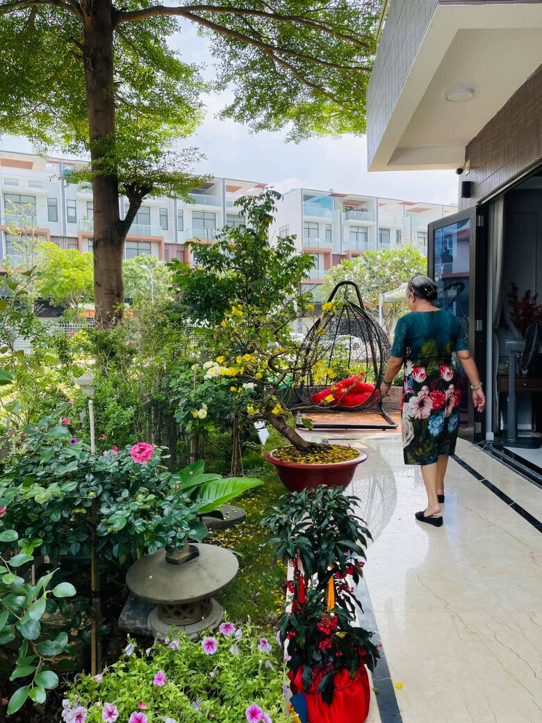 Mẹ ruột của Nhật Kim Anh thư thái dạo bước và tự tay chăm chút cho những đóa hồng tươi thắm trong vườn. Phía sau bà là chiếc xích đu tổ chim lót đệm đỏ, nơi các thành viên có thể ngồi thư giãn, trò chuyện cùng nhau.