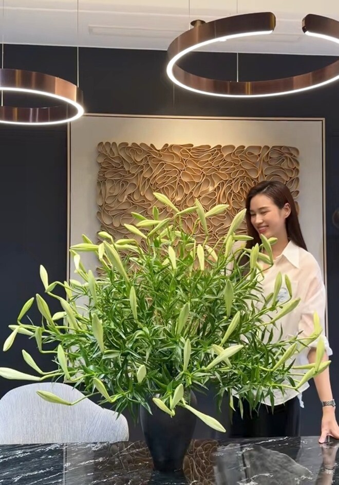 Nàng hậu rạng rỡ bên cạnh bình hoa đã hoàn thành phần khung cơ bản trước khi hoa nở. Tác phẩm có kích thước lớn, tương xứng với không gian nội thất hiện đại và tối giản của căn hộ.