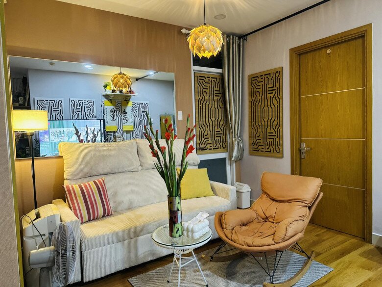 Dưới ánh đèn chùm nghệ thuật và không gian nội thất gỗ, đóa hoa vươn cao kiêu sa, góp phần khẳng định phong cách sống đầy chất thơ của chủ nhân căn hộ.