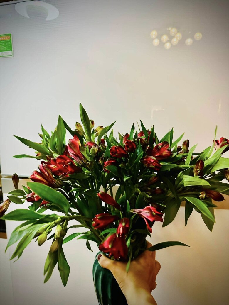 Đôi bàn tay khéo léo của nữ ca sĩ nâng niu bình hoa thủy tiên rực rỡ sau khi hoàn thành. Sắc xanh mướt mắt của lá cây đan xen cùng những nụ hoa chớm nở hứa hẹn sẽ mang đến luồng sinh khí mới mẻ cho căn phòng trong suốt tuần dài.