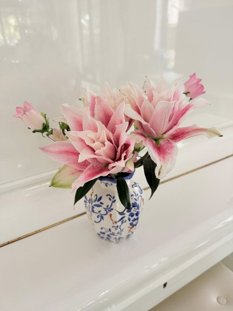  Những bông ly kép hồng nhạt kiêu kỳ được cắm gọn gàng trong bình gốm họa tiết xanh trắng cổ điển. Sự kết hợp này mang lại cảm giác nhẹ nhàng, ấm cúng khi đặt trên mặt đàn piano sang trọng.