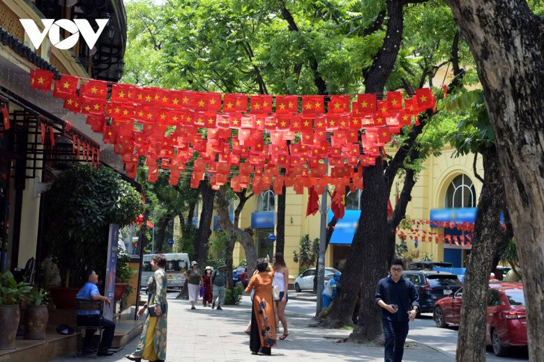Cờ đỏ sao vàng phủ sắc phố phường: Nét đẹp bình dị lan tỏa trong đời sống đô thị - 1