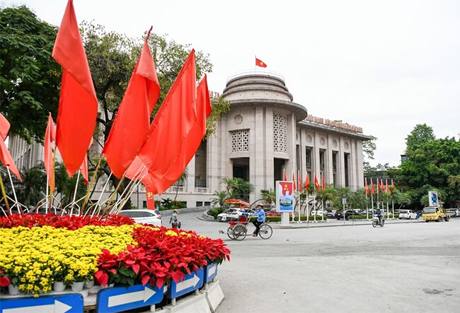 Khu vực trước trụ sở Ngân hàng Nhà nước Việt Nam được trang hoàng với hàng cờ đỏ sao vàng, cờ búa liềm.