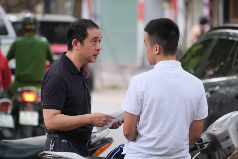 Bố mẹ đang cùng sĩ tử đang tranh thủ từng phút ôn lại bài trước khi vào khu vực thi 