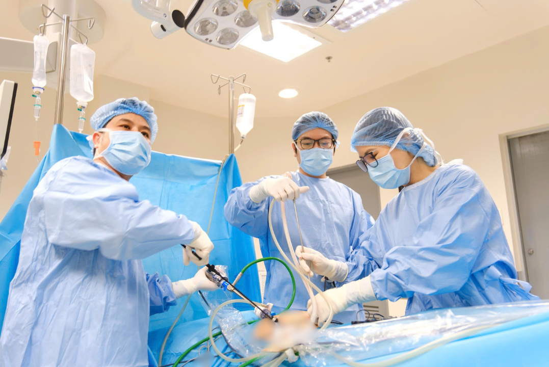 Bác sĩ Võ Triệu Đạt (giữa) và ê-kíp phẫu thuật nội soi cho bệnh nhân. (Ảnh: FV)