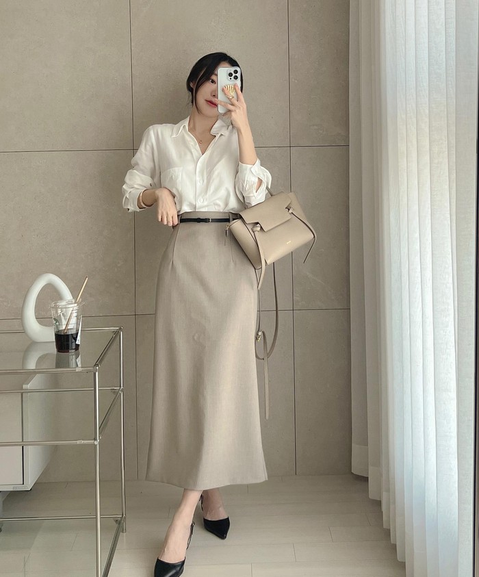 Áo sơ mi kết hợp chân váy tạo cảm giác nữ tính và tinh tế. Công thức này phù hợp với môi trường công sở nhờ sự thanh lịch và dễ ứng dụng.