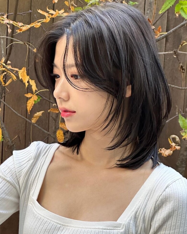 Tóc ngang vai mái bay giúp che khuyết điểm như trán cao, gương mặt góc cạnh. Phần mái ôm nhẹ hai bên tạo cảm giác mềm mại, nữ tính, đồng thời giúp diện mạo trẻ trung, hack tuổi hiệu quả mà vẫn giữ được nét thanh lịch.