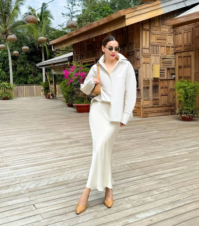 Hồ Ngọc Hà từng nhận nhiều lời khen khi xuất hiện với set đồ gồm áo sơ mi trắng phom rộng phối cùng chân váy lụa dáng midi màu trắng ngà.