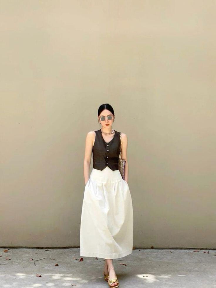 Áo tank top không tay phối cùng chân váy midi là công thức giúp vẻ ngoài vừa tối giản vừa sang trọng.