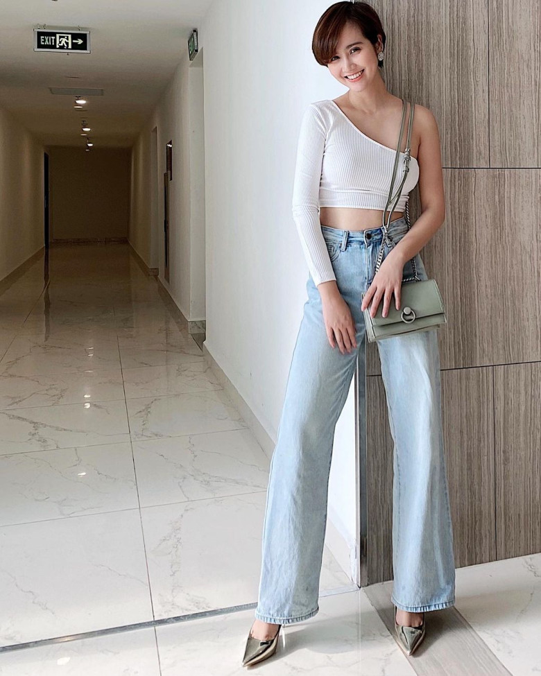 Huyền Lizzie đầy cá tính khi mix quần jeans với áo croptop lệch vai dài tay.