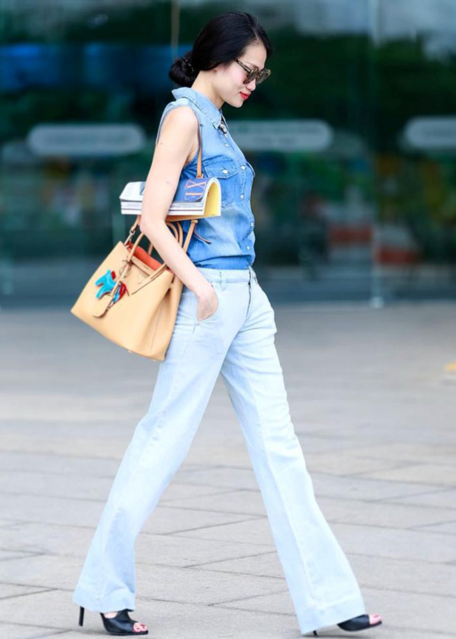 Cựu người mẫu Thanh Trức kết hợp chất liệu jeans một cách khéo léo khi chọn màu quần loe nhạt hơn so với tone của áo.
